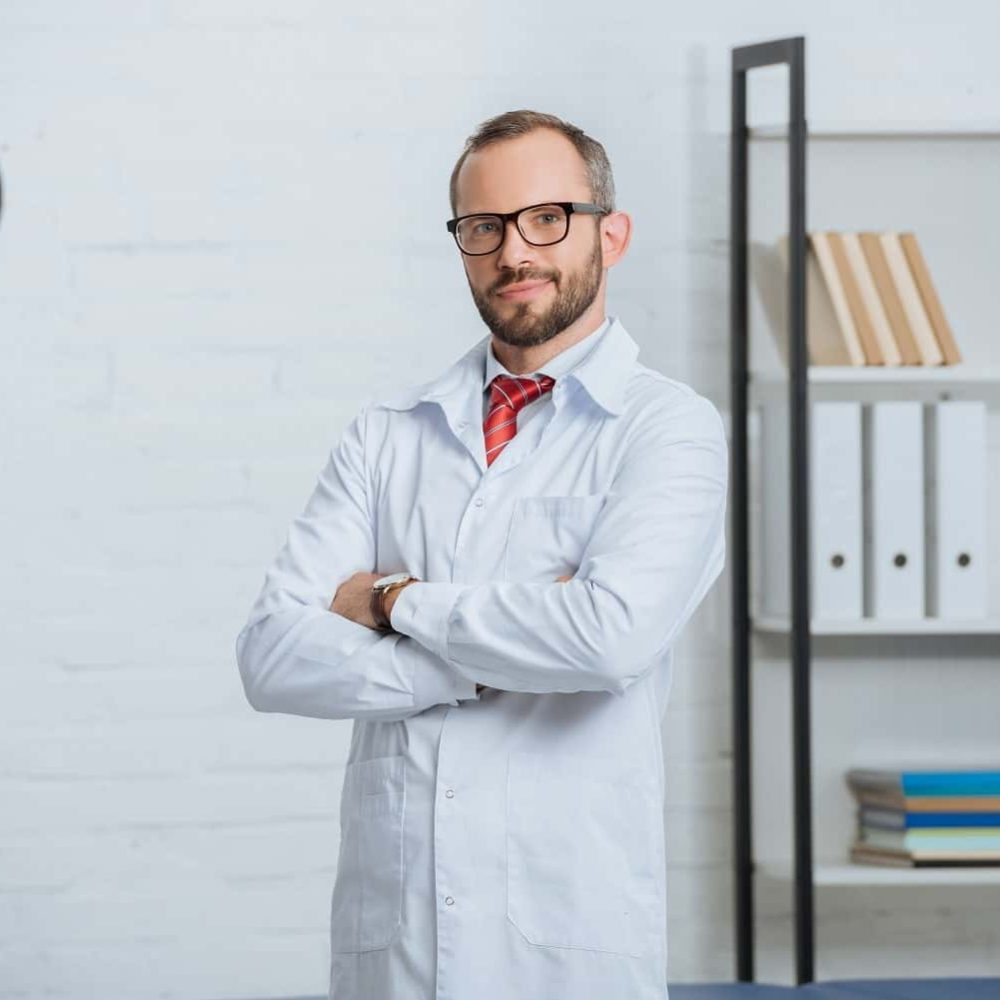 portrait-of-male-chiropractor-in-white-coat-and-ey-2022-11-02-02-22-21-utc-min-min.jpg